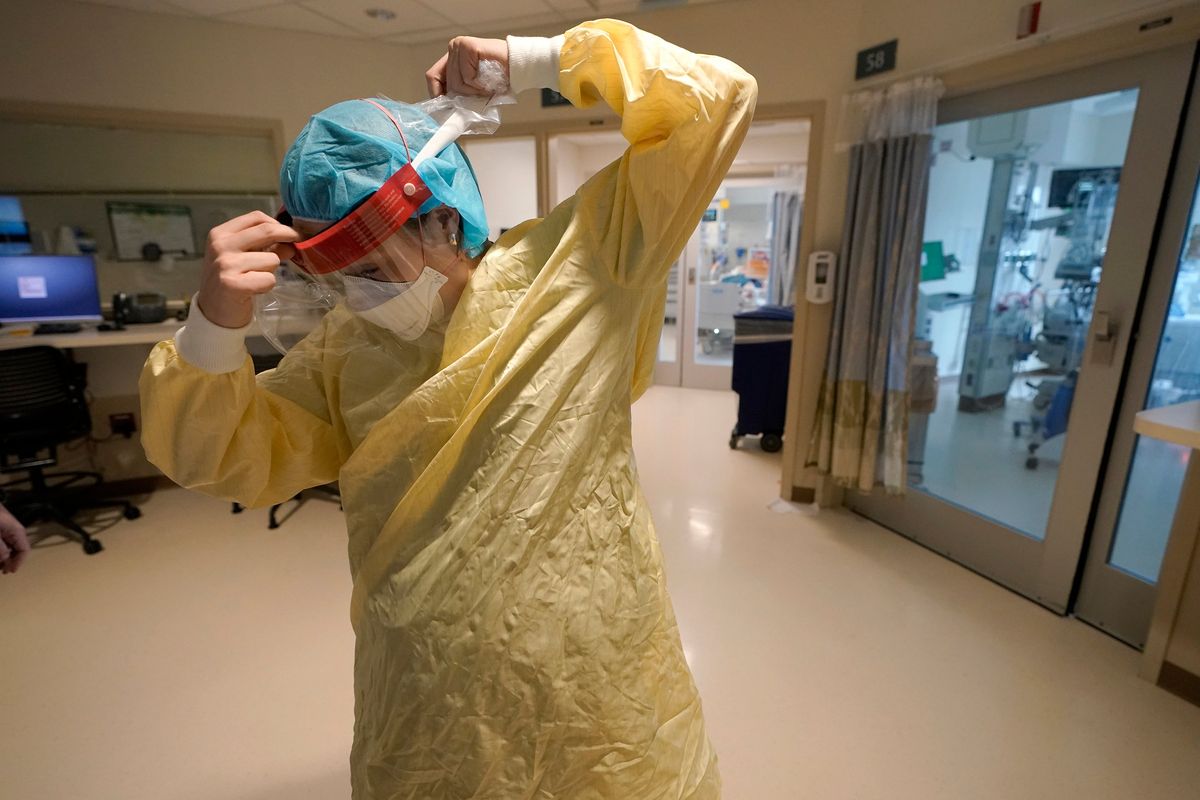 Registered nurse Sara Nystrom, of Townshend, Vt., prepares to enter a patient’s room Jan. 3 in the COVID-19 Intensive Care Unit at Dartmouth-Hitchcock Medical Center in Lebanon, N.H.  (Steven Senne)