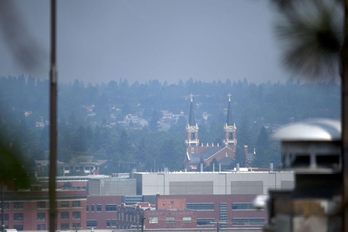 The Cathedral of Our Lady of Lourdes is surrounded by smoke from nearby fires in Spokane on Wednesday, Aug. 8, 2018. (Kathy Plonka / The Spokesman-Review)