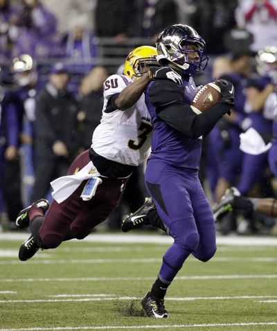 Washington's John Ross is tackled from behind by Arizona State's Damarious Randall during a kickoff return on Saturday night. (Associated Press)