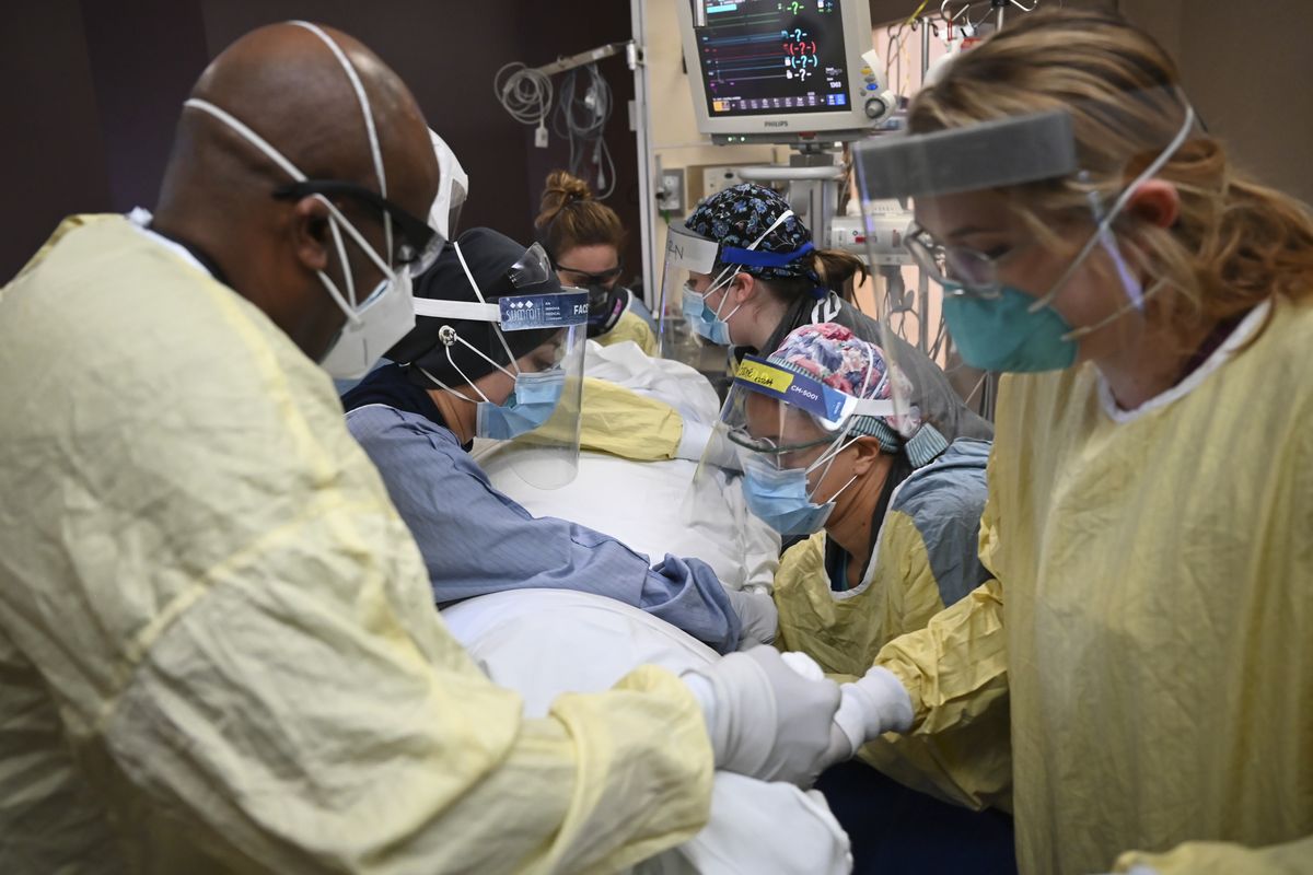 FILE - In this Monday, Dec. 7, 2020, file photo, critical care nurses and respiratory therapists flip a patient with COVID-19 upright at North Memorial Health Hospital in Robbinsdale, Minn. Virtually every state is reporting surges in cases and deaths.  (Aaron Lavinsky)