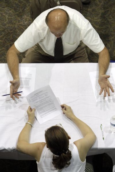 A job applicant receives advice on his resume while attending a job fair in Southfield, Mich., in August 2010. (Associated Press)