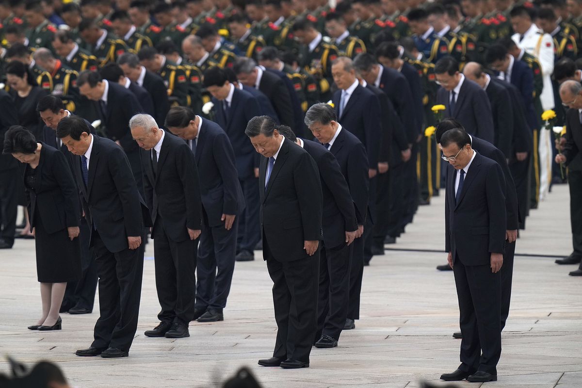 Chinese President Xi Jinping, center, leads other members of the Chinese Politburo Standing Committee including Premier Li Keqiang, right, to bow as they pay respects before the Monument to the People