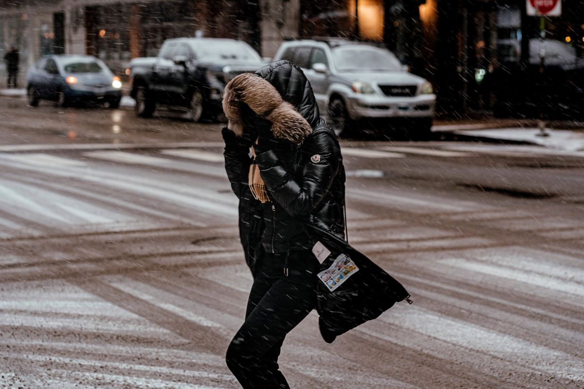 A woman braces herself from high winds and snow while crosses a street in Chicago, on Thursday, Dec. 22, 2022. A sprawling winter storm is moving into the eastern United States and Canada on Friday, knocking out electricity to more than a million customers and upending holiday travel. (Jamie Kelter Davis/The New York Times)  (JAMIE KELTER DAVIS)