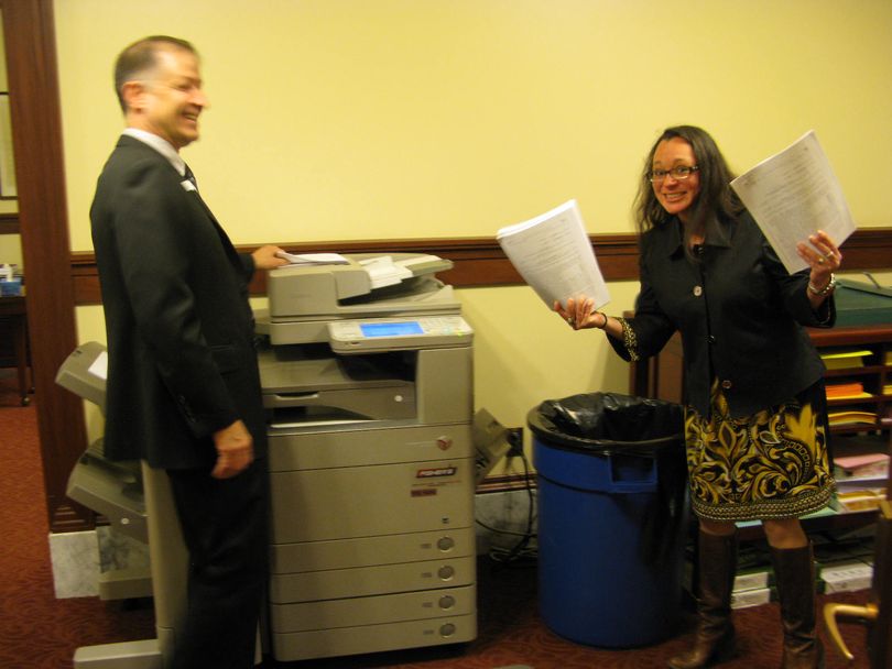 Jennifer Novak, secretary of the Senate, with newly printed copies of the transportation bill; at left is Sen. Dan Johnson, R-Lewiston (Betsy Russell)