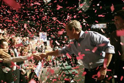 
President Bush shakes hands with supporters while on stage with Texas Gov. Rick Perry at a campaign rally at Reunion Arena on Monday in Dallas. 
 (Associated Press / The Spokesman-Review)