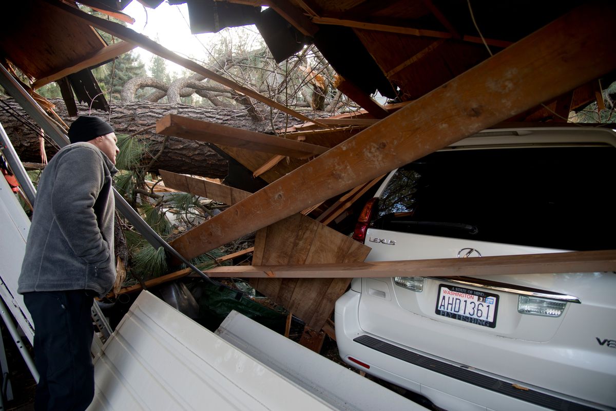 Matt Van Vleet, who lives on 18th Ave., east of Bernard, surveys the damage to his garage and two cars from a neighbor