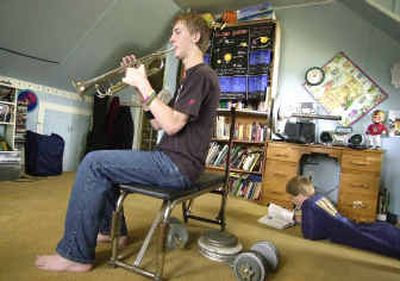 
Dylan Wilson, left, practices trumpet in his bedroom while brother Dallas lies on the floor, studying, as part of their home study program in Myrtle Point, Ore.
 (Associated Press / The Spokesman-Review)