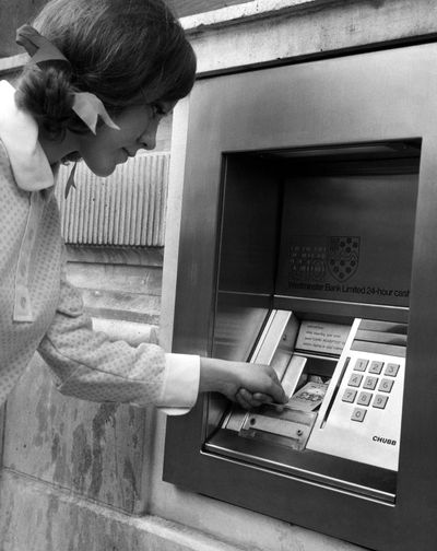 A woman puts her computer punch card into the slot of an automated teller machine outside a bank in central London in January 1968.The first ATM was installed in London in 1967, with John Shepherd-Barron being credited with inventing the machine. (Associated Press)