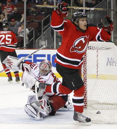 New Jersey’s Mattias Tedenby, right, celebrates his goal in the first period against Carolina goalie Cam Ward on Tuesday. (Associated Press)
