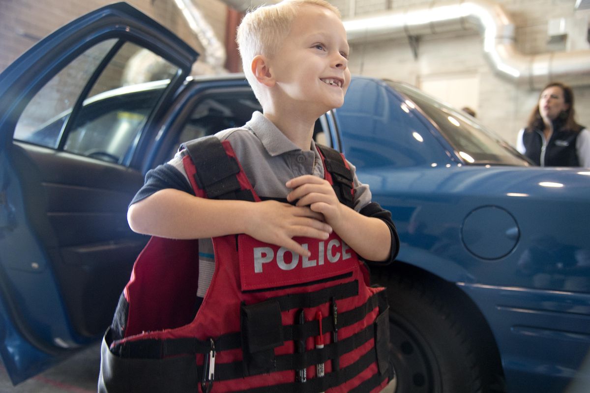 Grayson Mortlock, 6, tries on a ballistic vest during a fire station visit with a couple of police officers present Sunday at the station on Rebecca Street near Mission Avenue in Spokane. The tour was for families with kids with autism so  the kids could interact and become familiar with law enforcement and firefighters. (Jesse Tinsley / The Spokesman-Review)