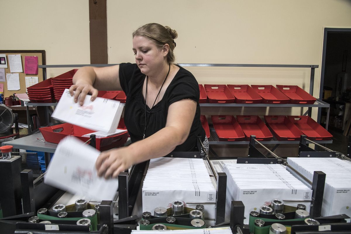 Spokane County election worker Sheralee Van Ry gathers ballots that were sorted by machine into precincts, Oct. 25, 2016, at the election center. (Dan Pelle / The Spokesman-Review)