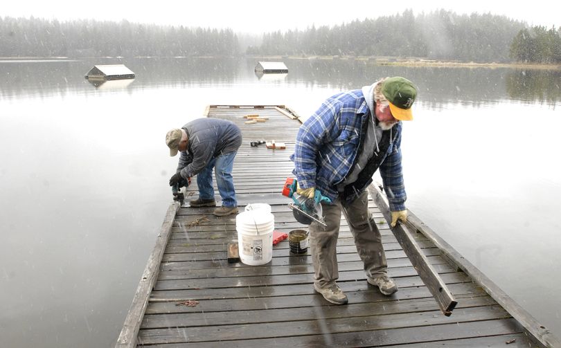 ORG XMIT: IDLEW102 Corky Loo, left, and Glenn Shea make minor repairs as they prepare a fishing dock for spring fishing at Winchester Lake State Park, even as winter makes a statement Wednesday, April 29, 2009 in Winchester, Idaho.(AP Photo/Lewiston Tribune, Barry Kough) (Barry Kough / The Spokesman-Review)