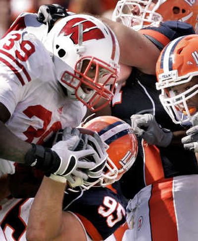 Wisconsin's P.J. Hill meets a wall of Illinois defenders, led by Doug Pilcher (95), during the second half Saturday. Associated Press
(Associated Press / The Spokesman-Review)