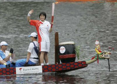 
A torch relay runner stands on a dragon boat Friday during the  Olympic torch relay in Hong Kong. Associated Press
 (Associated Press / The Spokesman-Review)