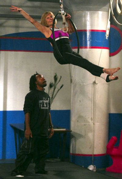 
Watched by acrobat trainer Donald Hughes, Elizabeth Herring gets a feel for her routine Friday at the St. Louis City Museum.
 (TPN / The Spokesman-Review)