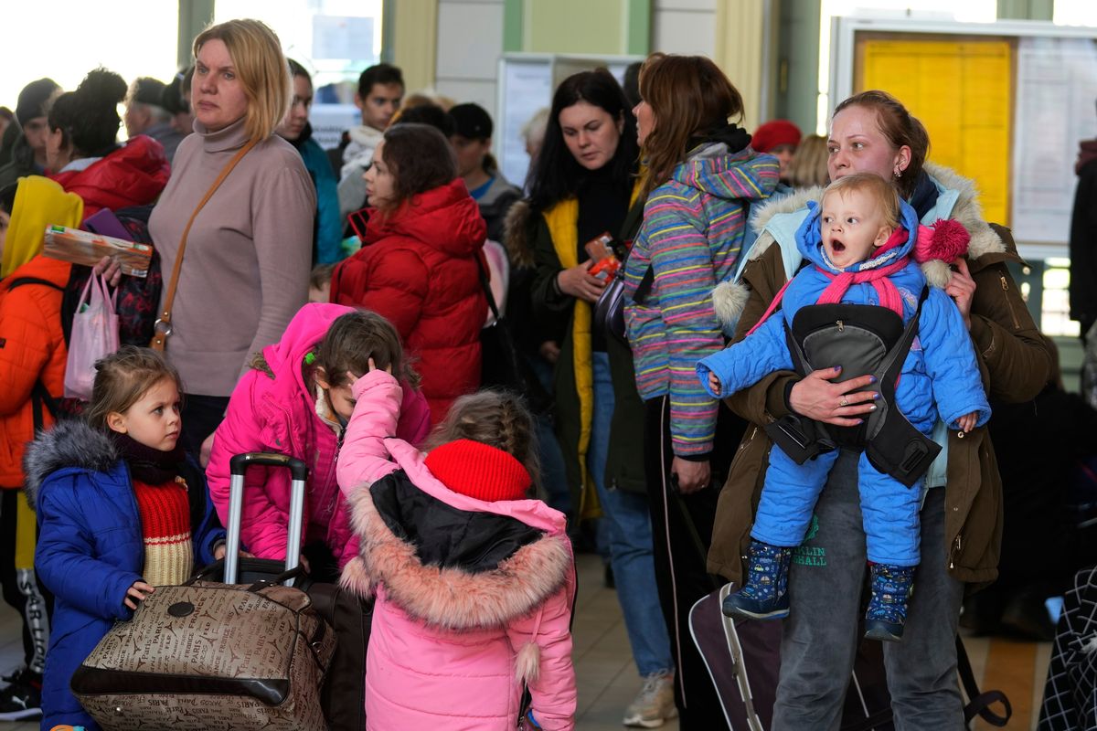 Ukrainian Marina Stadnik from Kramatosrk, right, arrives with her four children at a train station in Przemysl, southeastern Poland, Monday, March 28, 2022. The more than month-old war has killed thousands and driven more than 10 million Ukrainians from their homes – including almost 4 million from their country.  (Sergei Grits)