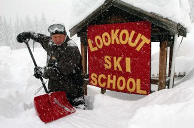 
Buried thigh-deep, ski school director Chris Creighton shovels out around the school sign at Lookout Pass Ski Area on the Idaho-Montana border Friday. Snowpack has reached 