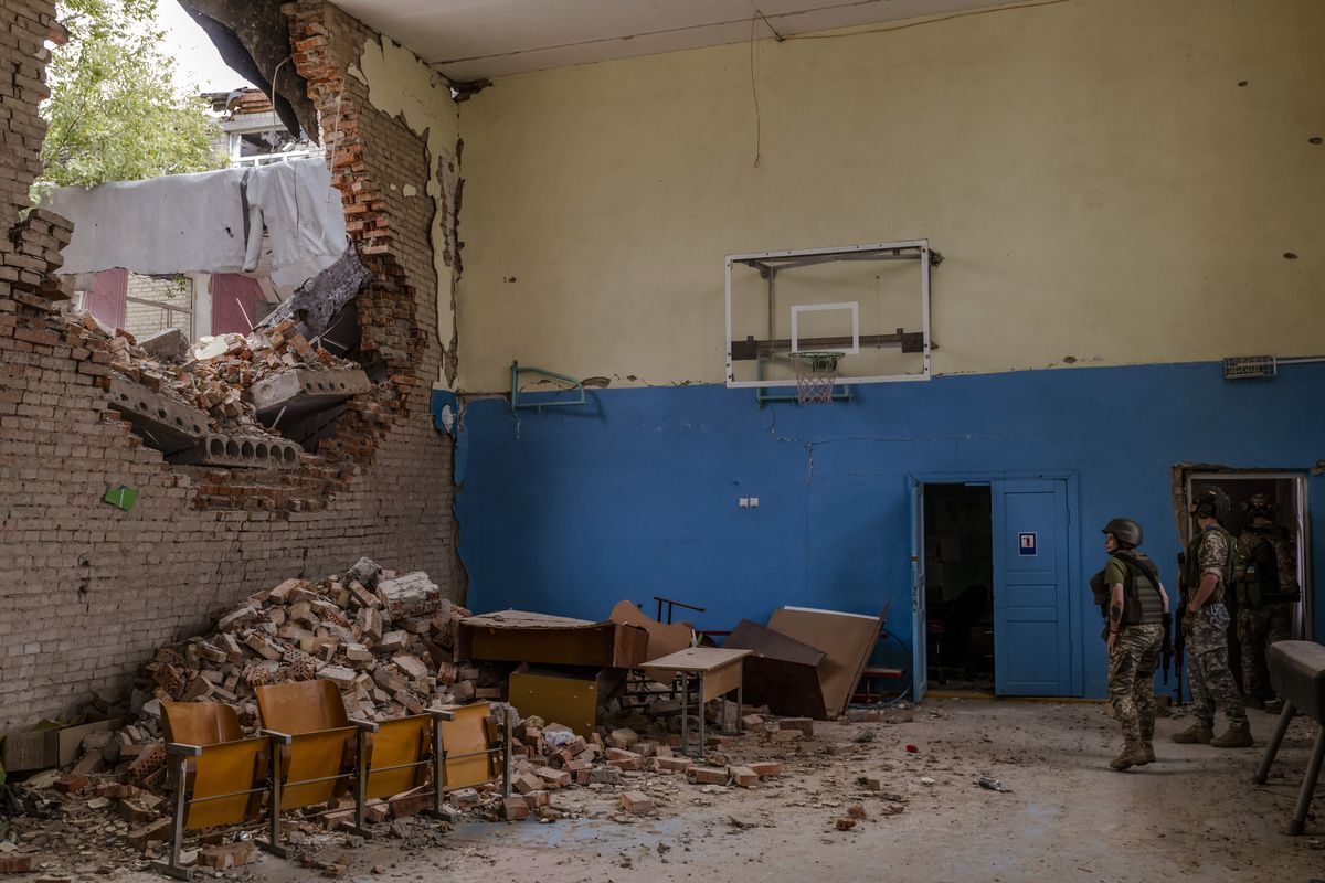 Ukrainain soldiers walk through the ruins of a school in the Mykolaiv region of southern Ukraine, a few miles from the Russian lines in the Kherson region, on Thursday, Aug. 11, 2022. Despite recent pronouncements by Ukraine