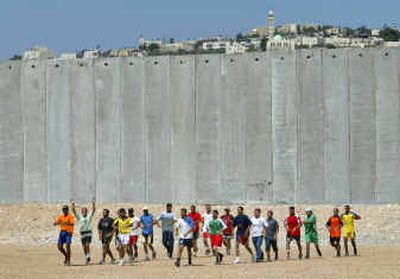 
Palestinian students, members of the Al Quds University soccer team, practice backdropped by part of Israel's separation barrier in the West Bank town of Abu Dis, in the outskirts of east Jerusalem on Tuesday.Palestinian students, members of the Al Quds University soccer team, practice backdropped by part of Israel's separation barrier in the West Bank town of Abu Dis, in the outskirts of east Jerusalem on Tuesday.
 (Associated PressAssociated Press / The Spokesman-Review)