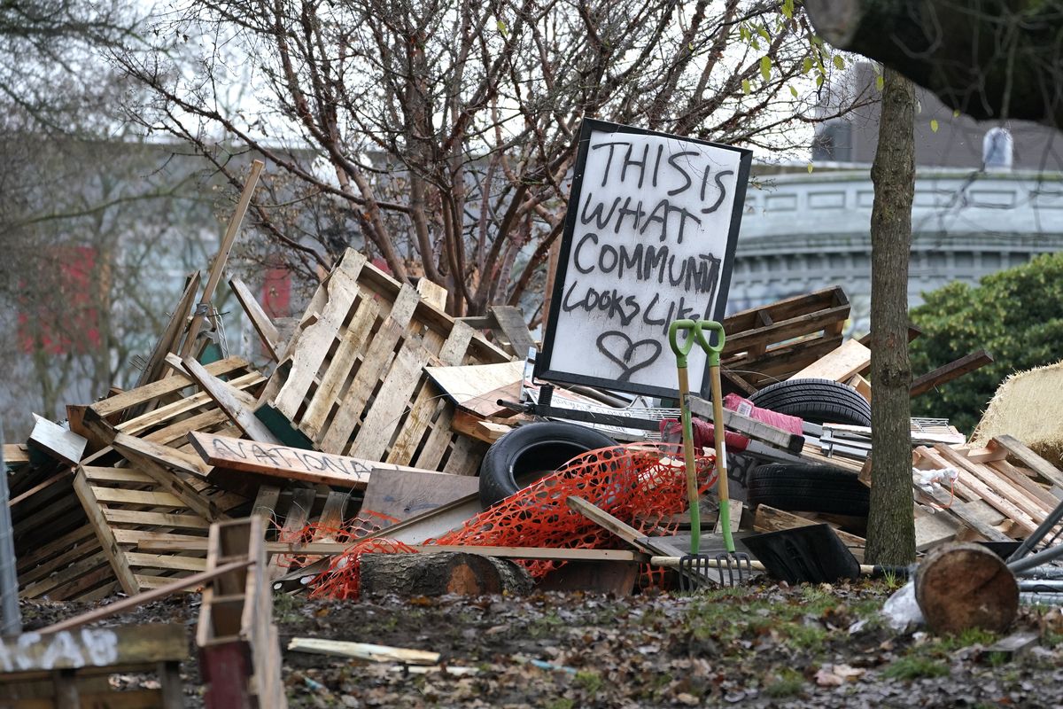 A sign that reads “This is what community looks like,” sits on top of a pile of debris and belongings at an encampment Dec. 18 that was occupied by people lacking housing at Cal Anderson Park in Seattle.  (Associated Press)