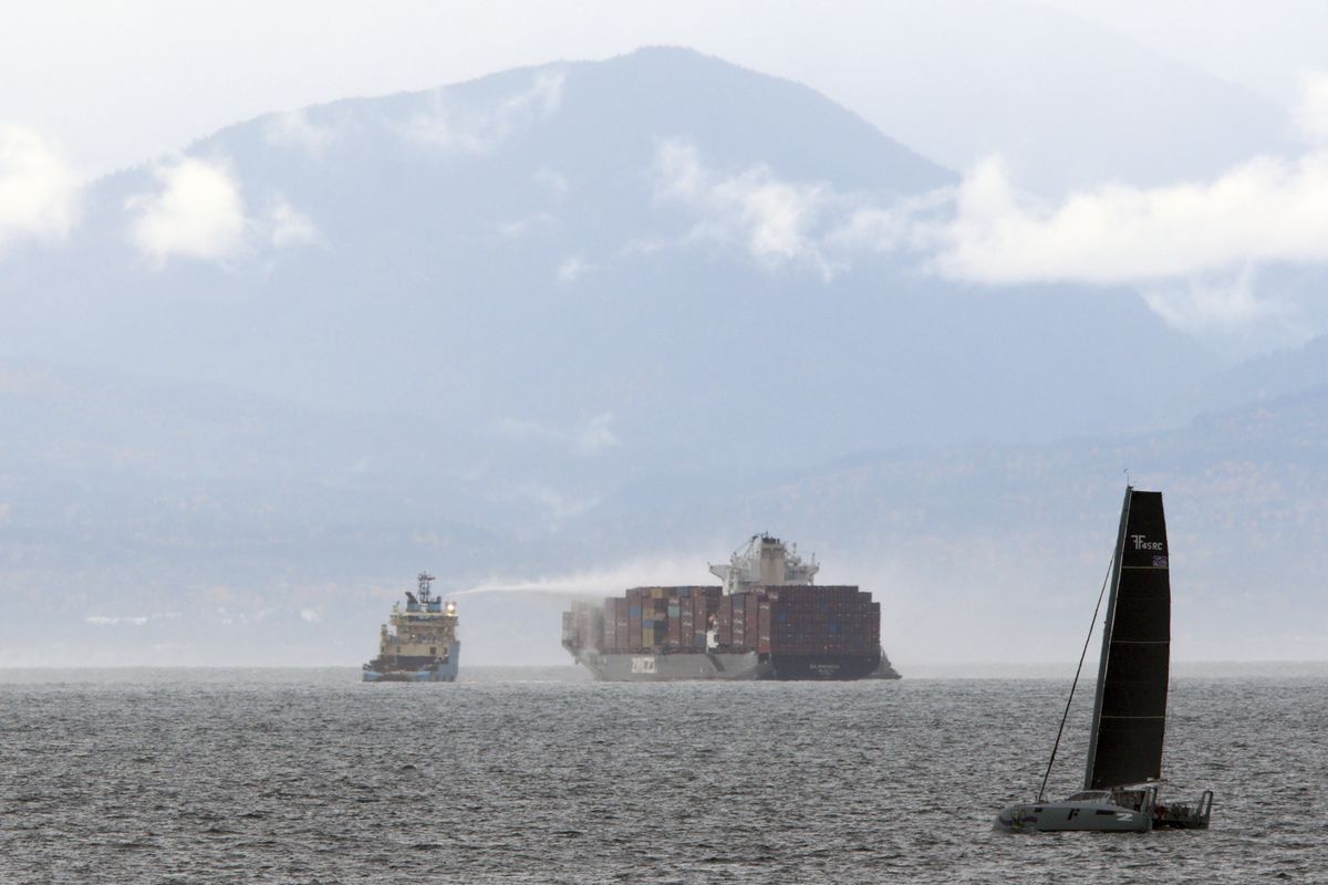 Ships work to control a fire onboard the MV Zim Kingston about 5 miles from the shore in Victoria, British Columbia, Sunday, Oct. 24, 2021. The container ship caught fire on Saturday and 16 crew members were evacuated and brought to Ogden Point Pier. (Chad Hipolito)