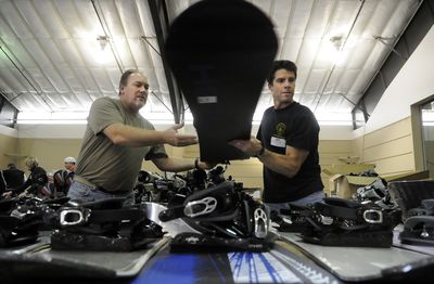 Dave Maxwell, left, and Chris Schilbe work to set up  for the Mt. Spokane Ski Swap this weekend at the Spokane County Fair and Expo Center.  (Photos by DAN PELLE / The Spokesman-Review)