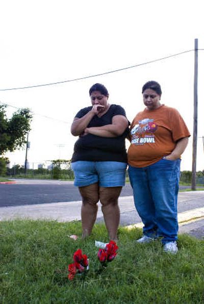
David Morales' sister, Margaret, left, and mother, Mary Helen, grieve at a memorial  Wednesday. David Morales was beaten to death Tuesday after the car he was in apparently struck a child. Associated Press
 (Associated Press / The Spokesman-Review)