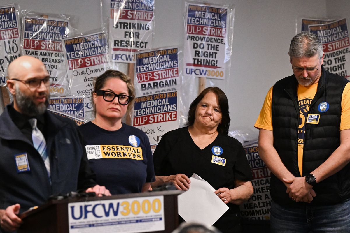 Respiratory therapist Theresa Bowden, second right, reacts with pediatric sonographer Shane Sullivan, far right, as cardiovascular technician Derek Roybal and UFCW 3000 president Faye Guenther answer a question from reporters about the breakdown in contract negotiations between the union and Providence Sacred Heart during a UFCW 3000 press conference in April 2024, announcing Providence Sacred Heart medical technicians’ plans to strike the following week at the UFCW 3000 offices in Spokane.  (Tyler Tjomsland/The Spokesman-Review)