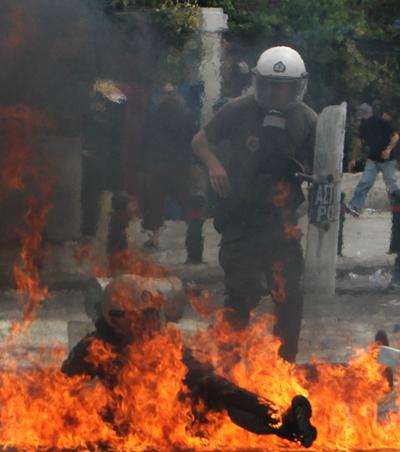 A riot police officer is engulfed in flames from a fire bomb thrown by protesters in central Athens on Wednesday. Protesters tried to storm Greece’s parliament.  (Associated Press)