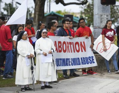 In this Jan. 22, 2017, photo, the Guam Catholic Pro-Life Committee holds its annual “Chain for Life” protest against abortion at the Guam International Trade Center intersection in Tamuning, Guam. The first female governor of Guam says she’s concerned that a lack of abortion access in the U.S. territory means women will be forced to seek illegal or dangerous alternatives. (Frank San Nicolas / Associated Press)