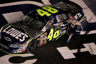 
A crew member presents Jimmie Johnson with a checkered flag. 
 (Associated Press / The Spokesman-Review)
