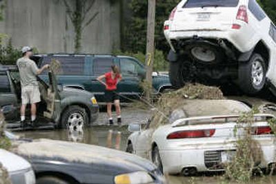
Joe and Tracey Gendron retrieve personal belongings Tuesday from their automobile after it was washed away in Monday's flooding caused by Tropical Storm Gaston in the Shockoe Bottom area of Richmond, Va. 
 (Associated Press / The Spokesman-Review)