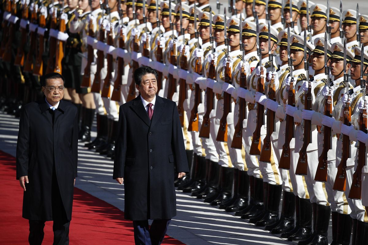 Japanese Prime Minister Shinzo Abe, right, and Chinese Premier Li Keqiang review an honor guard during a welcome ceremony at the Great Hall of the People in Beijing, Friday, Oct. 26, 2018. (Andy Wong / Associated Press)
