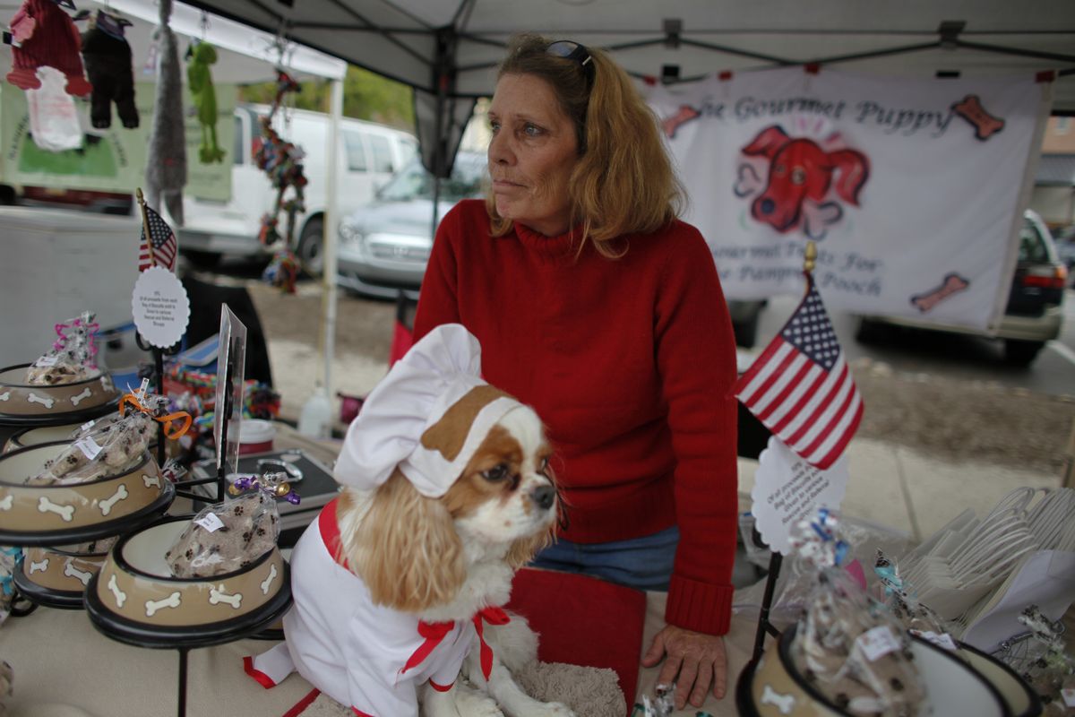 Cynthia Kopp and her dog Aires wait for customers at a farmers market, Saturday Oct. 6, 2012, in Doylestown Pa. Kopp, 56, lost her accounting job in the recession and now works part-time as a supermarket cashier and comes to the farmers market each week to sell $5 bags of her gourmet dog biscuits.  "If Aries could vote he would vote for Romney," Kopp said. "Because mommy needs a job and she thinks Romney is the only candidate that could help get her one." (Joseph Kaczmarek / Fr109827 Ap)