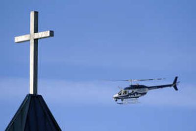 
A police helicopter flies above the New Life Church in Colorado Springs on Sunday after a man went inside and opened fire, killing a parishioner before being fatally shot by a guard. Associated Press
 (Associated Press / The Spokesman-Review)