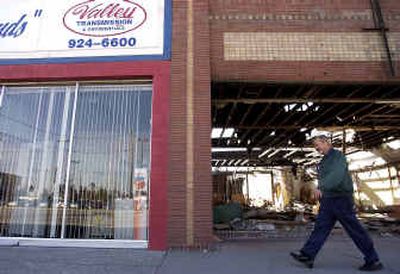 
Mike Holden, the owner of Valley Transmission at 8708 E. Sprague, walks past the burned-out building next to his business. The building was gutted by a fire four years ago.
 (Liz Kishimoto / The Spokesman-Review)