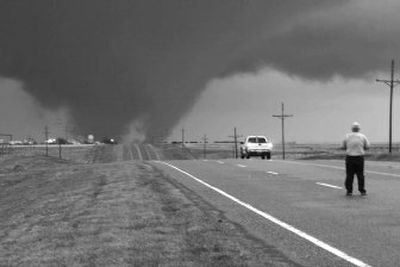 
A man stands in U.S. Highway 270 as a tornado crosses the highway  in Beaver County, Okla., on Wednesday. The storm that spawned the tornado killed at least four people in three states and continued on Thursday.
 (Associated Press / The Spokesman-Review)