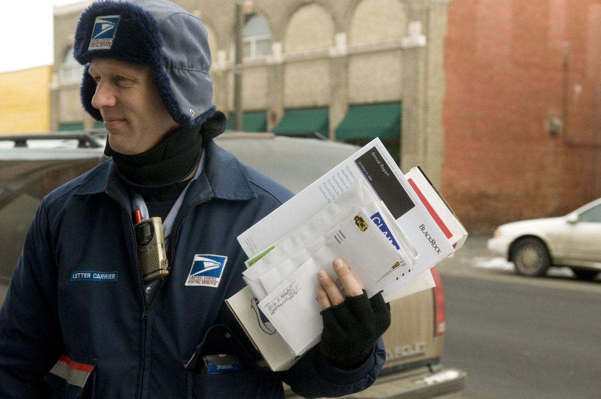 U.S. Postal Carrier Michael Meredith has been delivering mail in Hillyard for 13 years. When he put in for the Hillyard route, some colleagues said, “Hillyard? Are you crazy?”  (Photos by COLIN MULVANY / The Spokesman-Review)