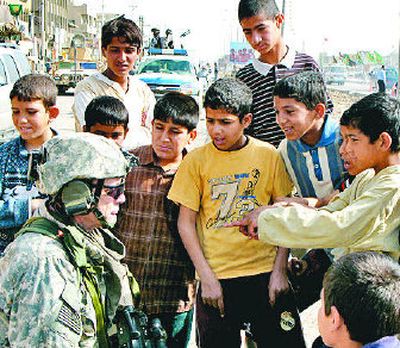 
Children gather around a U.S. Army soldier Wednesday in  the Sadr City area of Baghdad, where U.S. and Iraqi forces carried out a raid. 
 (Associated Press / The Spokesman-Review)