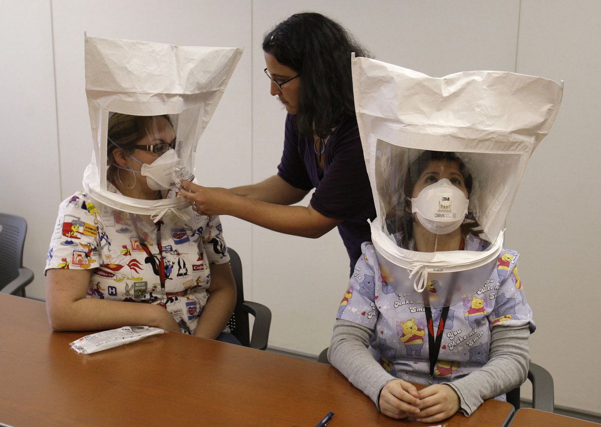 Karya Lustig, center, training manager at La Clinica de la Raza, trains clerks Mayra Torres, left, and Angelina Galvan in the use of a respiratory protection mask, which may be used for protection from the possible infection of the swine flu, Monday in Oakland, Calif.  (Associated Press / The Spokesman-Review)
