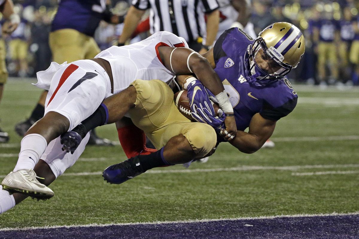 Washington’s Myles Gaskin, right, tumbles into the end zone for a touchdown on a pass reception as Fresno State’s James Bailey tries to hold him back at the end of the first half of an NCAA college football game, Saturday, Sept. 16, 2017, in Seattle. (Elaine Thompson / Associated Press)