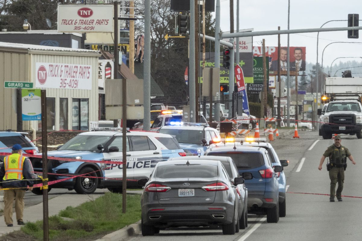 Spokane Valley police vehicles surround businesses near Trent Avenue and Girard Road on Wednesday in Spokane Valley while officers investigate a shooting.  (Jesse Tinsley/The Spokesman-Review)