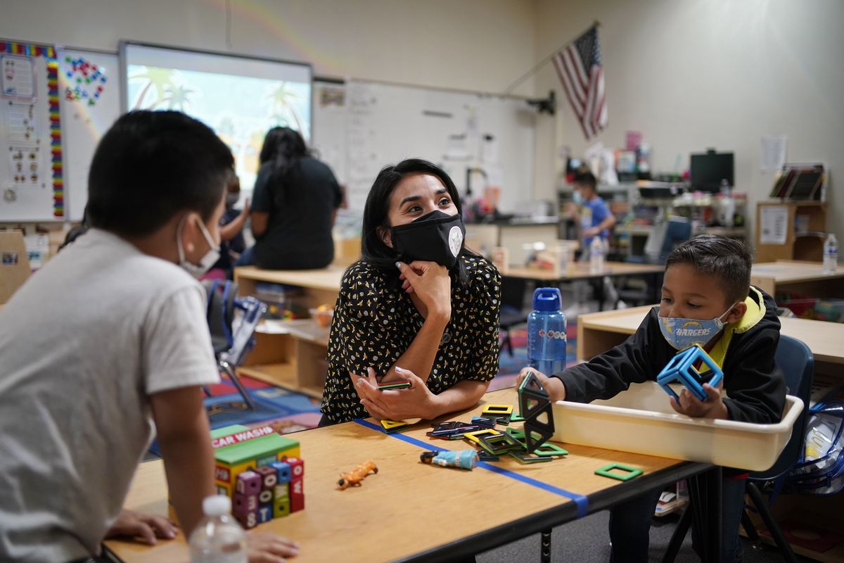 Teacher Juliana Urtubey, center, works with Brian Avilas, left, and Jesus Calderon Lopez, right, in a class at Kermit R Booker Sr Elementary School Wednesday, May 5, 2021, in Las Vegas. Urtubey is the the 2021 National Teacher of the Year.  (John Locher)