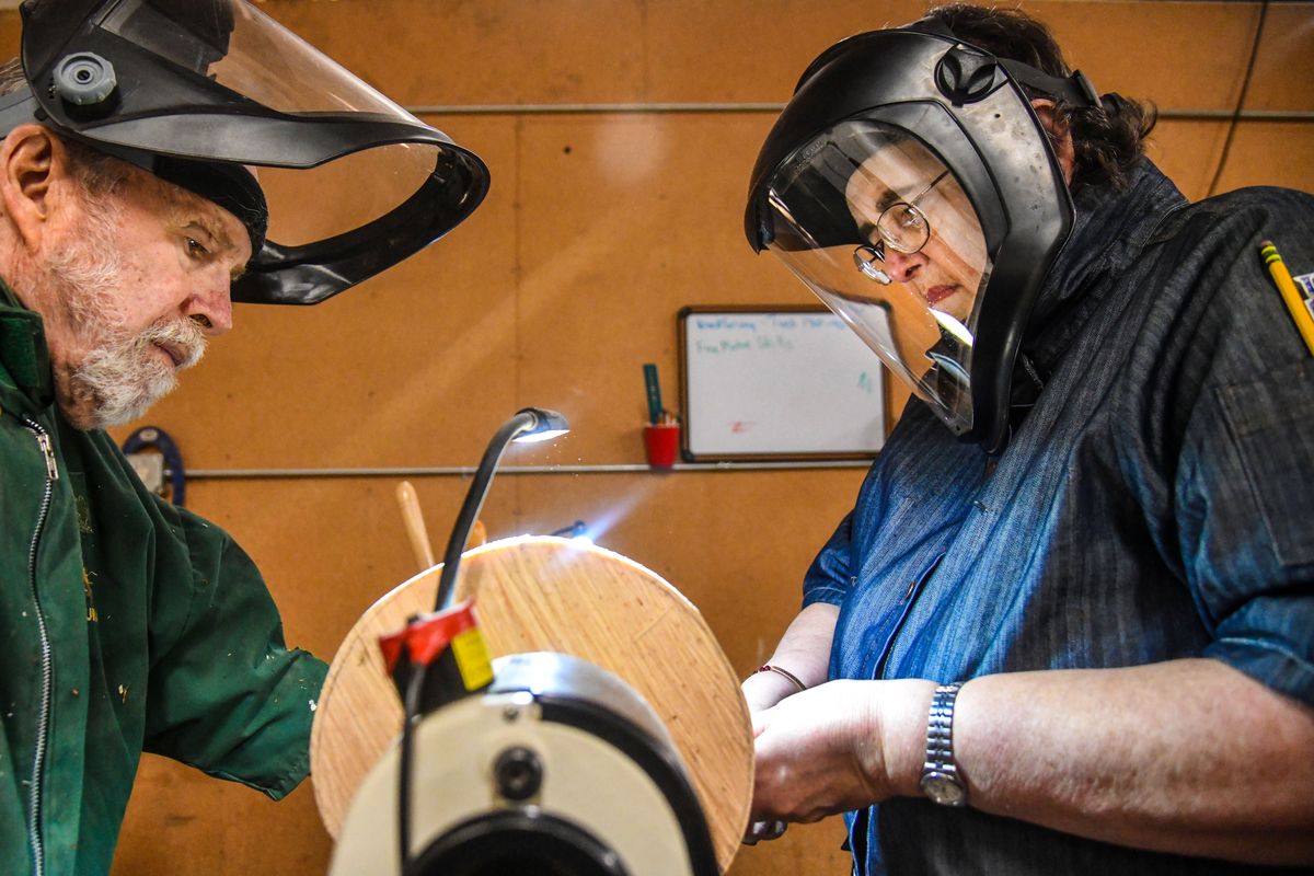 U.S. Army veteran Tzena Scarborough, right, focuses all her attention on a practice piece of wood as she learns under the guidance of Inland Northwest Woodturners President Doug Eaton, Tuesday, May 5, 2021, at the Vets Garage in Spokane.  (Dan Pelle/THE SPOKESMAN-REVIEW)
