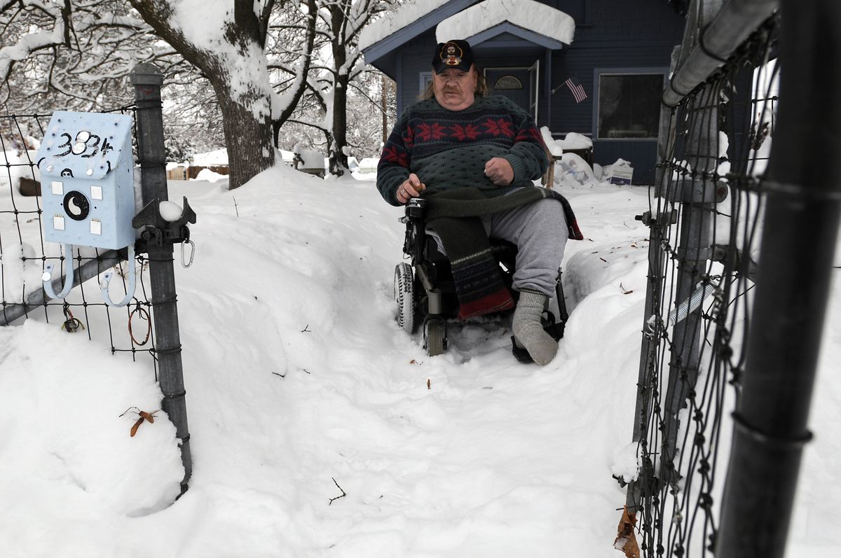 Gene Yoakum, of north Spokane, makes it down his ramp to the sidewalk and his mailbox on Friday. He lost a leg in an accident, then was partially paralyzed by a stroke. He still likes to get out to the bus stop and travel on days when he can find his way around the snow berms.  (Jesse Tinsley / The Spokesman-Review)