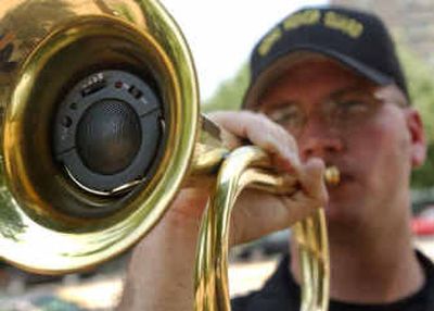 
Spcl. Michael Mauldin of the Maryland National Guard Honor Guard demonstrates an electronic device that can be placed inside a bugle to simulate the playing of taps during a funeral in Baltimore. With a large number of war veterans dying, the electronic bugle is being tested as a solution to a shortage of real bugle players. 
 (File/Associated Press / The Spokesman-Review)