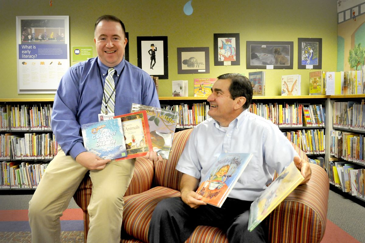Doug Stumbough, left, deputy director of the Spokane County Library District, acknowledges the donation of approximately 5,000 books, mostly children’s titles, from Jim Zahand, right, at the Spokane Valley Library on Friday. Zahand’s wife, Diane, who taught private school in Spokane Valley for many years, died last year and wanted her book collection to be used again. (Jesse Tinsley)