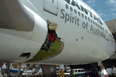 Qantas pilot Capt. John Francis Bartels looks at the damaged fuselage of a Qantas Airways Boeing 747-400 after it made an emergency landing Friday in Manila, Philippines.  (Associated Press / The Spokesman-Review)
