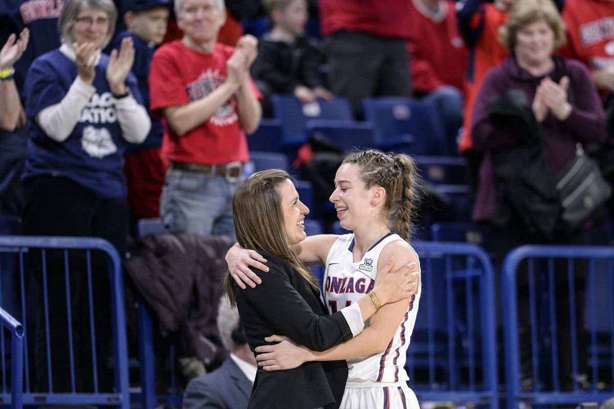 Gonzaga senior guard Emma Stach is welcomed to the bench by coach Lisa Fortier near the end of the game against BYU on Saturday. (Dan Pelle / The Spokesman-Review)
