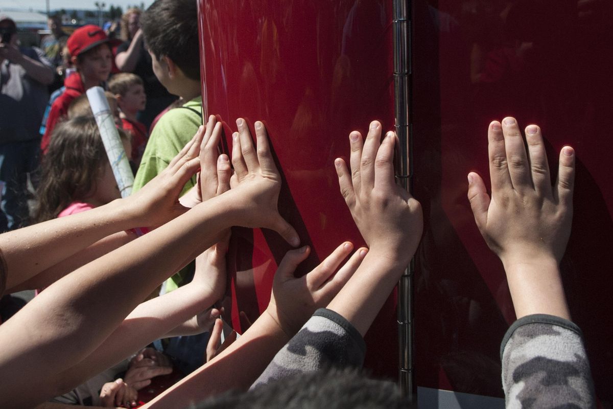 Children participate in the "push in" of Ladder 10 during the Spokane Valley Fire Department open house for Firehouse #13 on Saturday, April 22, 2017. (Kathy Plonka / The Spokesman-Review)